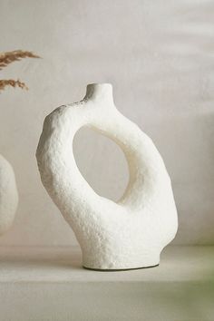 two white vases sitting next to each other on a table