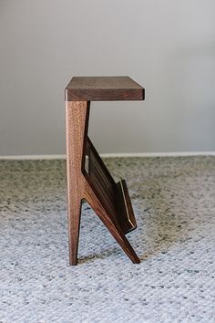 a small wooden chair sitting on top of a white carpeted floor next to a wall