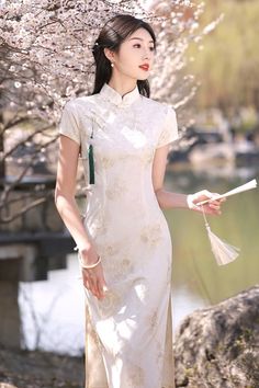 Discover a feminine long white cheongsam dress that is great for modern outfits. With its graceful long length, this cheongsam dress will flatter your body shape and highlight your waist. The charming white color adds a touch of sophistication to the long cheongsam. Elegant Ao Dai With Stand Collar For Spring, Elegant Spring Ao Dai With Stand Collar, Spring Formal Cheongsam With Stand Collar, Elegant White Cheongsam For Spring, Spring Elegant Cheongsam With Stand Collar, Elegant Spring Cheongsam With Stand Collar, Elegant Fitted Ao Dai For Summer, Elegant Long Cheongsam For Summer, White Cheongsam With Stand Collar For Wedding