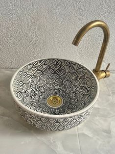 a sink that is sitting on top of a white countertop next to a faucet