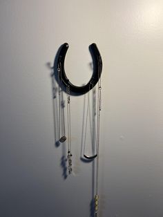 a black necklace hanging on the side of a wall