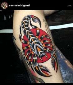 a colorful tattoo on the leg of a person with an orange, black and red crab