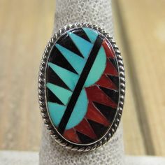 Vintage sterling silver southwestern multi stone inlay ring. The inlay consists of turquoise, jet, and coral. The face of the ring is approx 28 mm tall and approx 19 mm wide. It weighs 5.9g and has a band width of approx 3 mm. The ring is a size 6.75, we can size most rings for an additional fee, please message me with the size you need and I will get back to you with a price! Thank you for stopping by my shop! ! Multicolor Bohemian Turquoise Ring With Inlay, Multicolor Southwestern Sterling Silver Turquoise Ring, Multicolor Southwestern Style Turquoise Ring In Sterling Silver, Multicolor Southwestern Turquoise Sterling Silver Ring, Southwestern Multicolor Turquoise Sterling Silver Ring, Southwestern Multicolor Inlay Rings, Southwestern Style Multicolor Inlay Rings, Silver Flower Ring, Zuni Jewelry