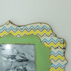 an old photo frame is decorated with colorful chevrons and a green border around it