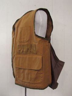 a brown vest hanging on a white wall