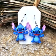 the earrings are shaped like stitchers and have pink ears