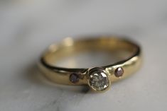 a close up of a gold ring with a diamond on it's side and two brown diamonds in the middle