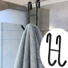 the towel rack is hanging on the wall in front of a shower door with two hooks