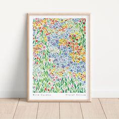 a colorful floral print with the words wild garden written in white ink on a wooden frame