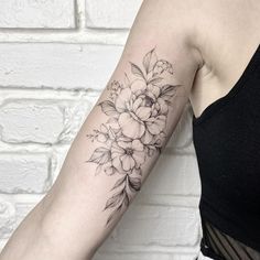 a woman's arm with a flower tattoo on the left side of her arm