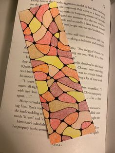 a bookmark made out of colored paper on top of an open book