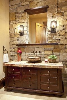 a bathroom with stone walls and wooden cabinets