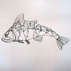 a drawing of a fish made out of wire and beads on a white wall background