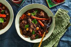 two bowls of beef stew with carrots, celery and parsley on the side