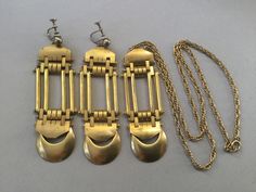 "Jakob Bengel brass watch fobs re-imagined and re-designed as rectangular pendant and screw back earrings. Great looking jewelry set. It would fall into the chunky category. Moderately heavy but very large pieces. Quite Avant Garde, Art Deco, Machine Age, Modernist. Created in the 30's and repurposed later. 1930s Necklace 24\" long 25.2 gram wt. (for pendant and necklace) Pendant: 3 1/4\" x 1\" Earrings: 3 1/4\" drop x 1\" W 17.9 gram wt (each earring) Attention: All items are listed to the best Vintage Bronze Rectangular Jewelry, Antique Bronze Rectangular Jewelry, Antique Rectangular Bronze Jewelry, Antique Rectangular Brass Jewelry, Vintage Brass Rectangular Jewelry, Vintage Rectangular Brass Jewelry, Vintage Rectangular Metal Earrings, Vintage Gold Jewelry With Brass Hardware, Rectangular Bronze Brass Jewelry