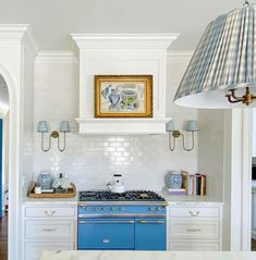 a blue stove top oven sitting inside of a kitchen next to a white counter top