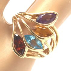 Exquisite 14 karat solid yellow gold ring bezel-set with four marquise-cut gemstones (amethyst, citrine, blue topaz, and garnet), each measuring approximately 7.78 millimeters long by 3.73 millimeters wide and weighing a total of 2.59 carats. The ring is approximately a size 4 1/2, and can be re-sized to fit by your local jeweler. It weighs approximately 5.33 grams. It is stamped 14KP, where the P stands for Plumb, or exactly 14 karat. Excellent estate condition. This ring is a perfect Mother's Yellow Gold Marquise Multi-stone Jewelry, Gold Multi-stone Marquise Cut Jewelry, Gold Marquise Birthstone Ring, Gold Marquise Birthstone Ring With Gemstone, Fine Jewelry Yellow Gold Marquise Amethyst Ring, Gold Marquise Amethyst Ring, Marquise Yellow Gold Amethyst Ring Fine Jewelry, Gold Marquise Amethyst Ring Fine Jewelry, Gold Marquise Amethyst Gemstone Ring