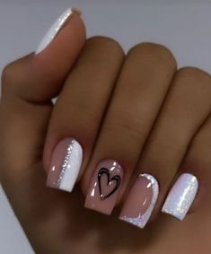 a woman's hand with white and pink nail polishes on her nails, holding a heart shaped manicure