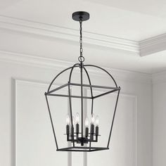 a chandelier hanging from the ceiling in a room with white walls and flooring