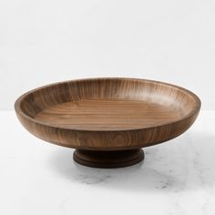 a wooden bowl sitting on top of a white table