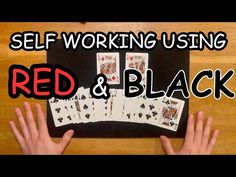 two hands holding playing cards with the words self working using red and black