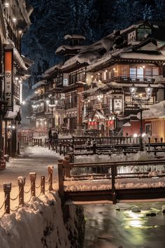 a snow covered town at night with lights on