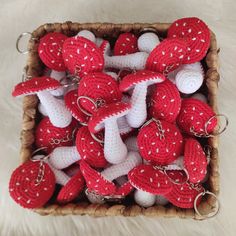 red and white crocheted keychains in a basket on a fur rug