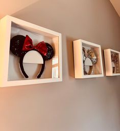 the wall is decorated with three mickey mouse head heads and two other disney ears on display