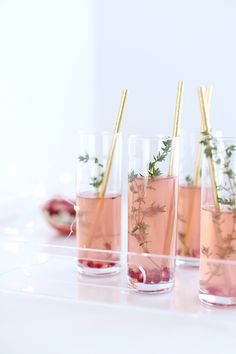 three glasses filled with drinks and garnished with herbs