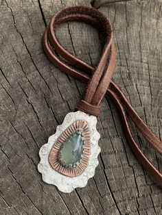 "This unique mixed metals pendant is entirely crafted by hand with primitive metalworking techniques. It features a very high quality aqua chalcedony gemstone with a copper & Sterling silver setting. The copper really makes the gemstone stand out in this piece. This pendant has lots of rustic charm, texture & patina. It is stamped with the Bible verse \"Nahum 1:17\". This would make the perfect inspirational gift for any occasion or as a reminder for oneself to always seek strength throu Artisan Necklace With Adjustable Patina, Artisan Chalcedony Pendant Necklace, Artisan Hand-tooled Necklace For Gift, Artisan Chrysoprase Necklaces For Jewelry Making, Silver Artisan Necklace With Patina, Artisan Silver Necklace With Patina, Artisan Teardrop Copper Necklace, Bohemian Teardrop Pendant Necklace, Hand Forged, Handmade Artisan Chrysoprase Jewelry