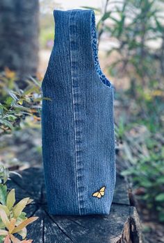 a blue bag with a butterfly on it sitting on top of a piece of wood