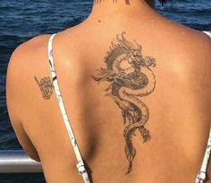 a woman with a dragon tattoo on her back