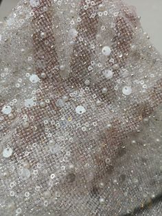 the fabric is covered with sequins and beads on it's surface,