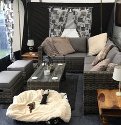 a living area with couches, tables and chairs in the middle of an open tent