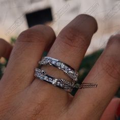 a woman's hand with two wedding bands on her finger and the ring is white gold