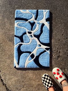 a person standing next to a blue and white tile on the ground with their feet up