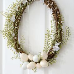 a wreath with eggs and greenery hangs on the door