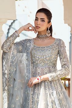 Bridal Gown Lehenga and Dupatta Pakistani Wedding Dress is an embellished masterpiece that will give the gorgeous bride a head-turning flawless look on the most important day of her life. Lavish designs and premium quality fabric make this Lehenga Dress an epitome of beauty. Pakistani Bridal Gown: Pakistani Bridal Gown has an alluring blue grey shade and is beautifully adorned with shimmering embellishments. Resham, dabka, crystals, sequins, and pearls enhance the glamour of this Pakistani Bridal Outfit. The Gown is fully embellished with intricate designs and silverwork. Bridal Lehenga: Pakistani Bridal Gown is paired with a huge flared Lehenga. Ruffles around the borders and premium organza give a perfect finishing to this gorgeous Lehenga. Ruffles enhance the charm and give a head-turni Glamorous Wedding Sets With Resham Embroidery, Embellished Anarkali Dress For Ceremony, Silver Hand Embellished Dress For Eid, Hand Embellished Silver Dress For Eid, Traditional Dresses With Zari Work For Marriage, Traditional Floor-length Gown For Wedding, Traditional Floor-length Gown For Marriage, Traditional Marriage Dress With Zari Work, Elegant Floor-length Sharara For Ceremony