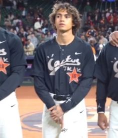 three baseball players standing next to each other in front of a stadium full of people