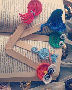 three crocheted sea creatures are on top of an open book