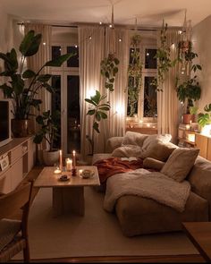 a living room filled with lots of furniture next to a window covered in plants and candles