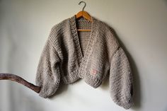 "Chunky Knit Cardigan, Cropped Chunky Sweater, Hand Knitted Jumper, Open Style Cardigan, Chunky Jacket, Sweater Women's Cozy, Beige Sweater Loose fit One size Oversized Color beige Lenght 16,53\" (42cm) Width 22\" (56cm) Lenght of sleeve 15,74\" (40cm) This warm cardigan is knitted by me from a thick yarn 5% Mohair, 10% Wool 85% Premium Acrylic Handmade. Clean by hand in very delicate detergent. Dry flat. Standard shipping is 10-16 days usually FAST SHIPPING Shipping via FedEx is also possible - Cozy Chunky Long Sleeve Sweater, Cozy Knitted Cropped Sweater For Fall, Casual Knitted Cropped Sweater For Fall, Casual Cropped Fall Sweater, Cozy Slouchy Cropped Sweater For Winter, Knitted Cropped Sweater For Fall, Cozy Chunky Knit Cropped Sweater, Slouchy Chunky Knit Cropped Sweater, Chunky Jacket