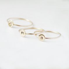 One gold letter ring. Personalize a gift she'll treasure with our gold initial ring. An adorably petite initial, imprinted on a 14k gold filled disk - paired with a super skinny (1mm) gold filled band - creates the perfect stacking ring, customized with your monogram. Lovely as a stand alone. Also sits beautifully with multiple initials stacked or our hammered gold stacking ring bands. This gold initial ring arrives custom made to order in your size hand stamped with the letter of your choice. A Simple Personalized Initial Ring For Everyday, Personalized Yellow Gold Initial Ring For Everyday, Everyday Stackable Yellow Gold Rings With Initials, Everyday Personalized Yellow Gold Initial Ring, Gold Sterling Silver Initial Stackable Ring, Gold Sterling Silver Stackable Initial Ring, Everyday Gold Hand Stamped Stackable Rings, Gold Stackable Rings With Initials For Everyday, Everyday Gold Stackable Rings With Initials