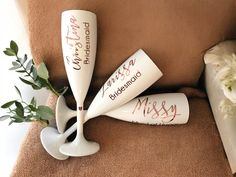 three personalized wine glasses sitting on top of a chair next to a vase with flowers