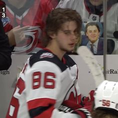 a hockey player sitting on the bench in front of fans