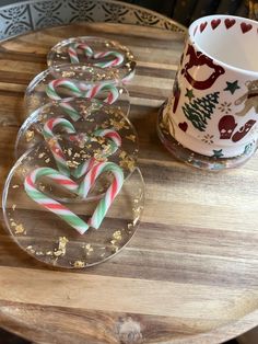 some candy canes are sitting on a table next to a cup and saucer