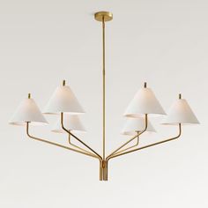 a brass chandelier with six white lamps hanging from it's center point