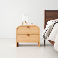 a bedroom with a bed, nightstand and mirror on the side table next to it