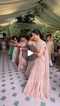 a woman in a pink sari dancing with other people