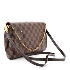 This is an authentic LOUIS VUITTON Damier Ebene Favorite MM. This stylish bag is crafted of classic Damier toile coated canvas. The shoulder bag features a polished gold tone chain-link wristlet strap and an optional leather crossbody strap. The crossover flap opens with a magnetic Louis Vuitton engraved gold tone bar to a red fabric interior with a patch pocket. Favorite Mm, Louis Vuitton Damier Ebene, Damier Ebene, Red Fabric, Stylish Bag, Crossbody Strap, Authentic Louis Vuitton, Louis Vuitton Damier, Chain Link